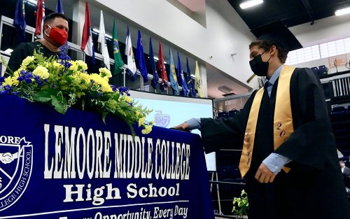 Grads picked up their diplomas off a table.